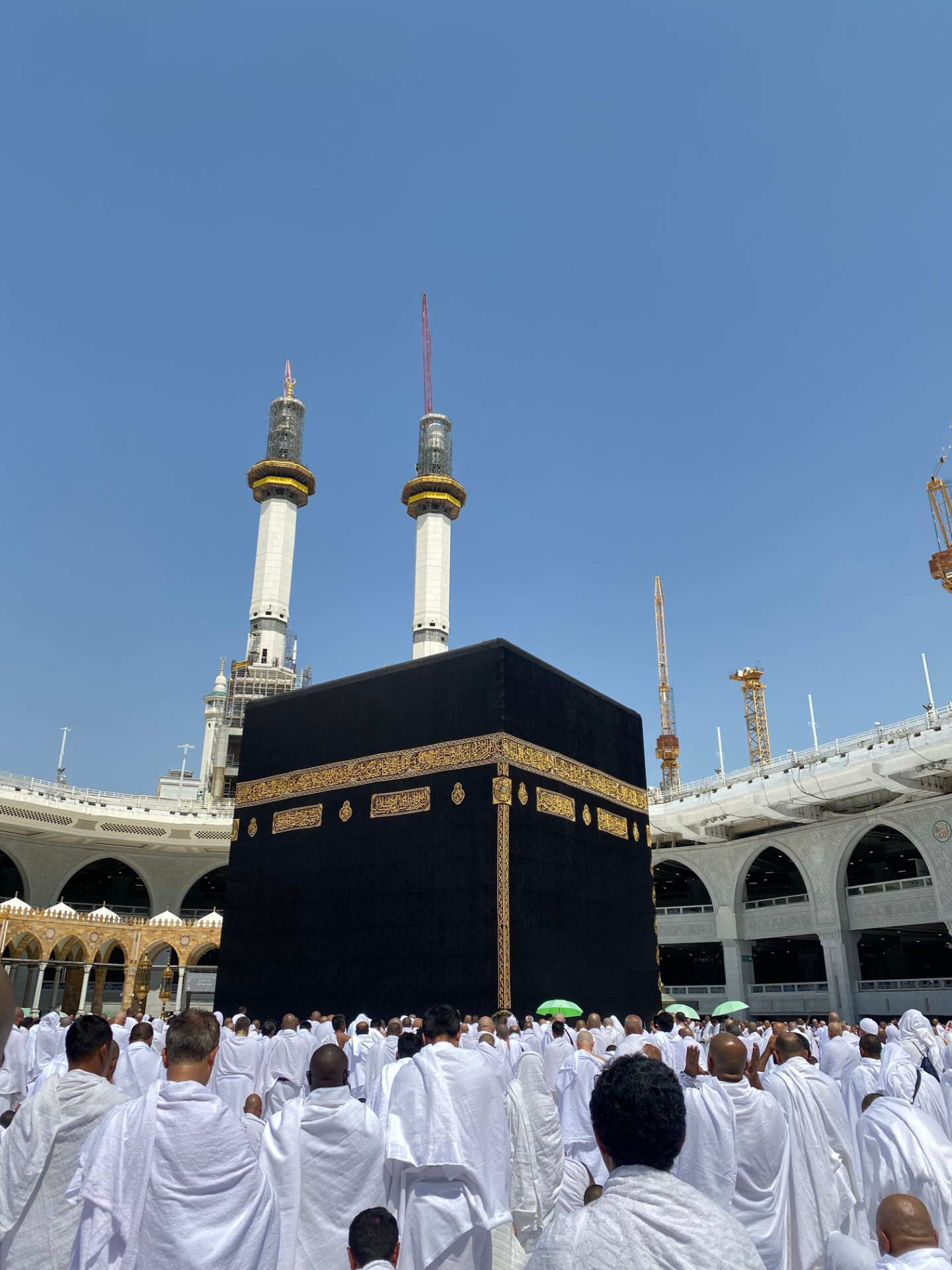 Pilgrims in ihram praying around the Kaaba in Masjid al-Haram